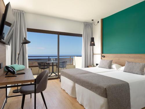 a hotel room with two beds and a view of the ocean at FERGUS Puerto de la Cruz in Puerto de la Cruz