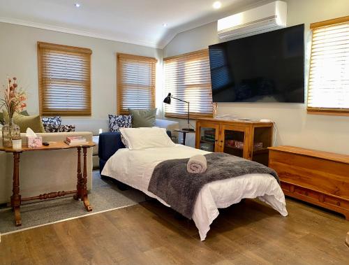 a bedroom with a bed and a tv and a couch at The Kabbage in Berridale