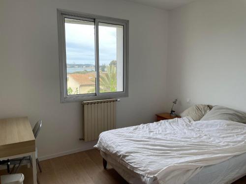 een slaapkamer met een bed en een raam bij Villa familiale à Sète in Sète