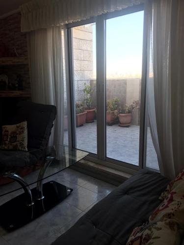a living room with a sliding glass door to a patio at Givat Zeev - between Jerusalem and Tel Aviv, 25 minutes from the airport in Giv'at Ze'ev