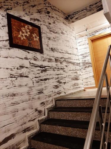 a staircase with a stone wall and a picture on the wall at Hotel Kafkasya in Kars