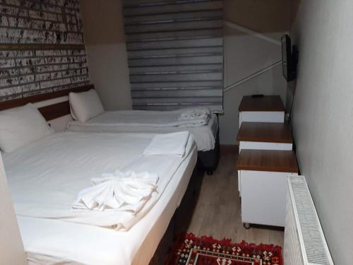 two beds in a small room with a staircase at Hotel Kafkasya in Kars