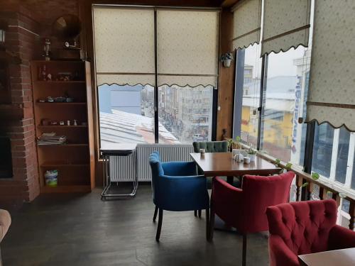 a dining room with a table and chairs and a window at Hotel Kafkasya in Kars