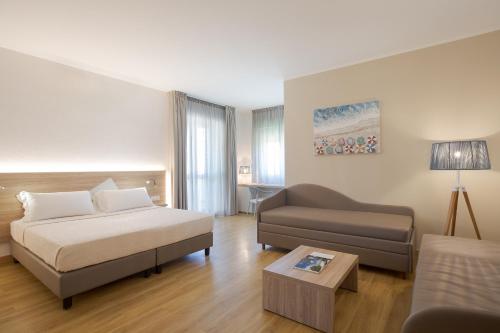 a living room with a bed and a couch at Lu' Hotel Porto Pino in SantʼAnna Arresi