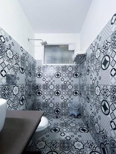 a bathroom with a black and white tiled wall at Seclude Kasauli, Himachal Pradesh in Kasauli