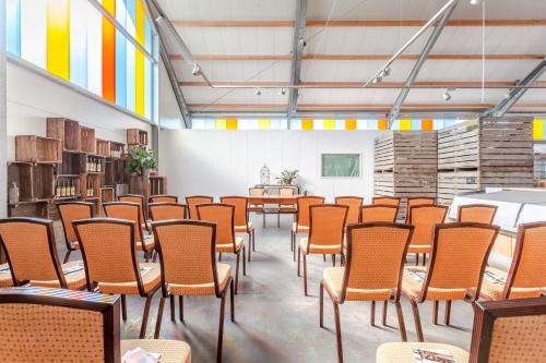 Cette grande chambre comprend des rangées de chaises et de tables. dans l'établissement Hajé Nieuwegein, à Nieuwegein
