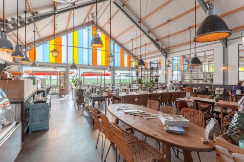 een restaurant met houten tafels en stoelen en glas-in-loodramen bij Hajé Nieuwegein in Nieuwegein