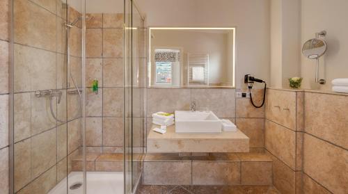 a bathroom with a sink and a shower at Hotel Villa Toskana in Leimen