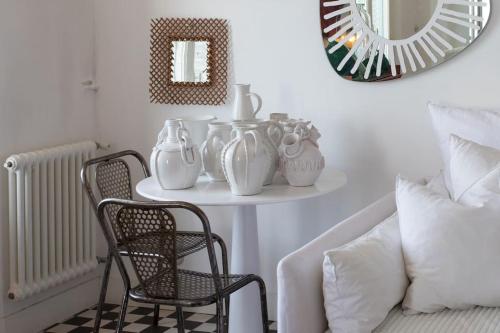 - une table avec des vases, une chaise et un miroir dans l'établissement L50 2P Rauba Capeu SEA View IloveNice Balcony&AC, à Nice