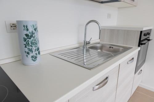 a white kitchen with a sink and a counter at Residence Il Poggio in Dorio