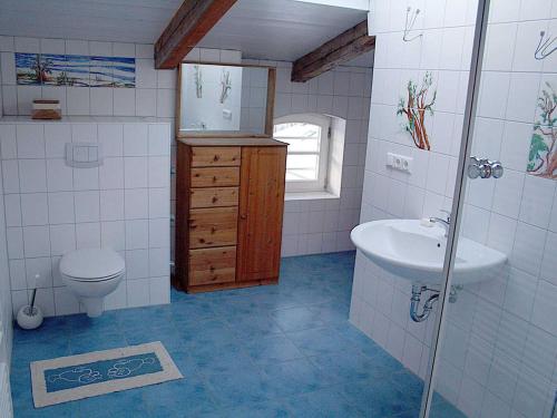 ein Badezimmer mit einem Waschbecken, einem WC und einem Spiegel in der Unterkunft Ferienwohnungen in Klausdorf in Klausdorf