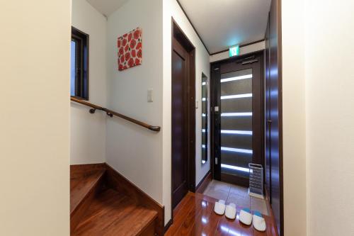 a hallway with a door and a stair case at City center Shibuya -都心縁渋谷- in Tokyo