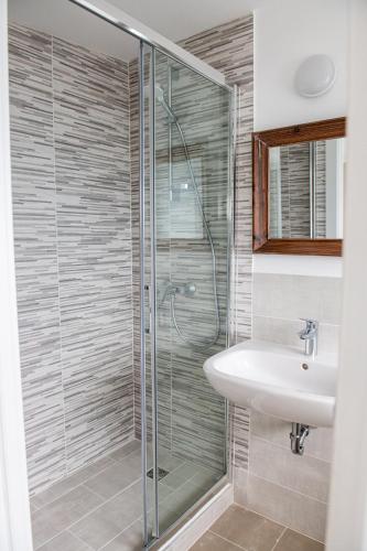 a bathroom with a glass shower and a sink at Residence Il Poggio in Dorio