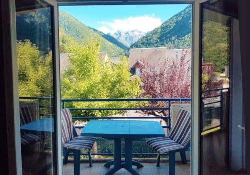 une table et des chaises sur un balcon avec vue dans l'établissement Appart 6 personnes esprit chalet vue sur montagne, à Saint-Mamet