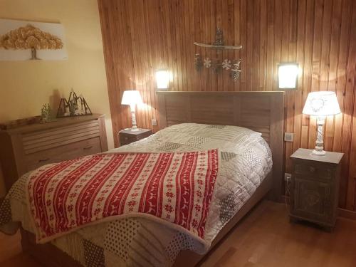une chambre avec un grand lit et deux lampes dans l'établissement Appart 6 personnes esprit chalet vue sur montagne, à Saint-Mamet