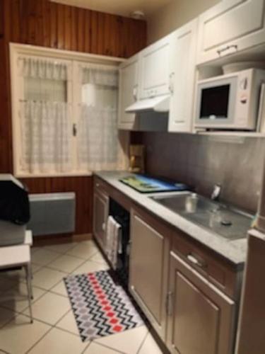 une cuisine avec un évier et une cuisinière dans l'établissement Appart 6 personnes esprit chalet vue sur montagne, à Saint-Mamet
