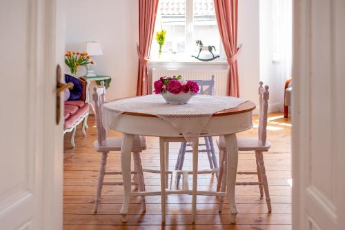 Kobieciarnia في تكيف: طاولة غرفة الطعام مع وعاء من الزهور عليها