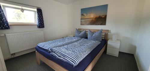 a bedroom with a bed with a blue and white comforter at Fewo Steuerbord in Rambin