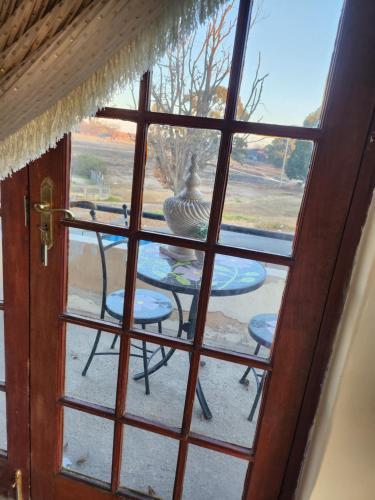 a view of a table and chairs through a window at Chateau De Vie in Krugersdorp