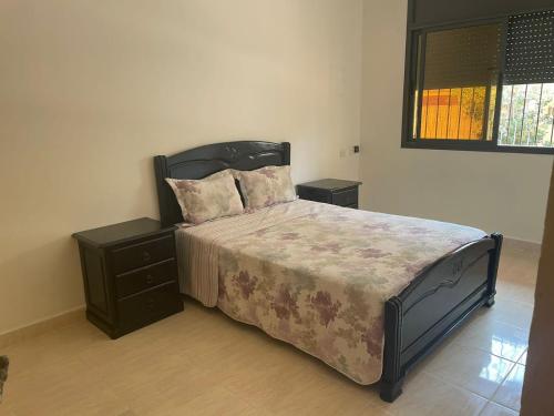 ein Schlafzimmer mit einem Bett mit zwei Nachttischen und einem Bett mit einem sidx sidx sidx in der Unterkunft Kenitra شقة in Kenitra