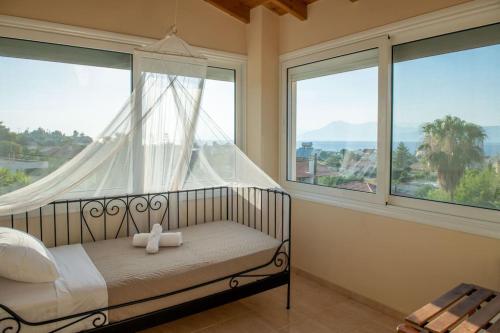 sypialnia z łóżkiem z baldachimem i oknami w obiekcie Villa Oasis Kato Alepochori w mieście Kato Alepochori