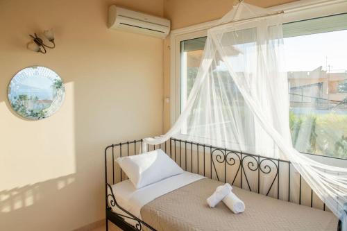 a bedroom with a bed and a large window at Villa Oasis Kato Alepochori in Kato Alepochori