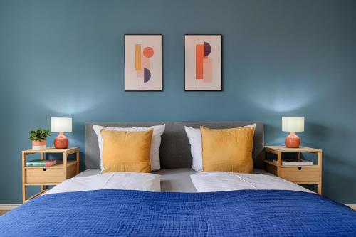 a blue bedroom with a bed and two lamps at homie stay Badgasse - Fewos am Main mit Dachterrasse & Fahrradgarage in Ochsenfurt