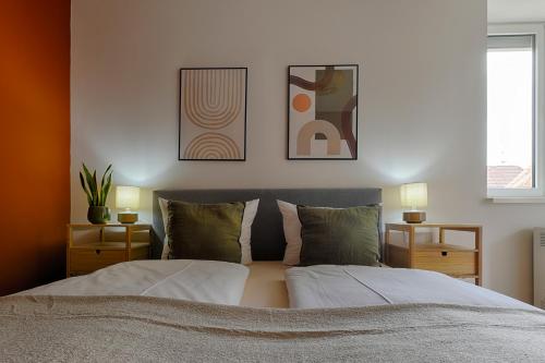 a bedroom with two beds and two pictures on the wall at homie stay Badgasse - Fewos am Main mit Dachterrasse & Fahrradgarage in Ochsenfurt