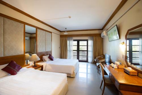 Habitación de hotel con 2 camas y escritorio en Eurasia Cha-Am Lagoon en Cha Am