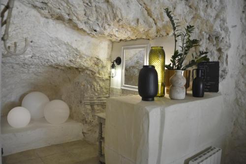 Cette chambre dispose d'une table avec des vases. dans l'établissement Les Troglos de la Tufolière, à Rochecorbon