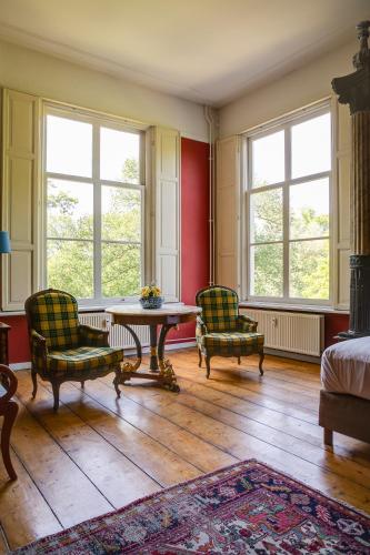 a room with two chairs and a table and windows at Kasteel Sterkenburg in Driebergen