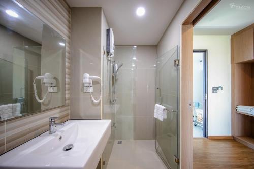 a bathroom with a sink and a shower at Phavina Grand Boutique in Rayong