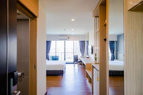 a hotel room with two beds and a hallway at Phavina Grand Boutique in Rayong