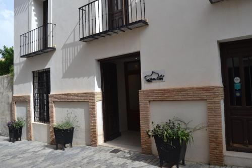 een wit gebouw met potplanten ervoor bij Hotel La Vera Cruz in Caravaca de la Cruz