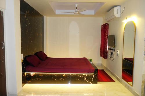 a bedroom with a red bed in the middle of it at Hotel HCB (Hemo Chandra Bhawan) in Brahmapur