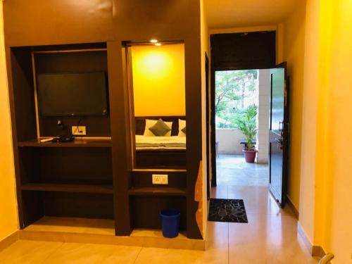 Habitación con dormitorio con cama y espejo. en The Hotel, en Mount Abu