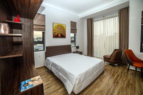 a bedroom with a bed and a chair and a window at KP Villa Dalat in Da Lat