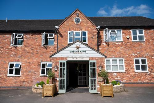 a red brick building with the front door open at Millers Hotel by Greene King Inns in Sibson