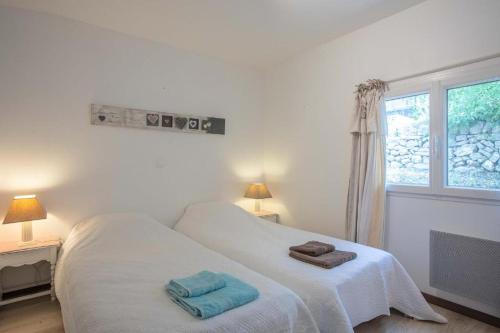 ein Schlafzimmer mit einem weißen Bett mit zwei Handtüchern darauf in der Unterkunft Le Mas Bello Visto in Lorgues