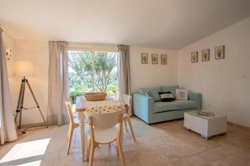 ein Wohnzimmer mit einem Tisch und einem blauen Sofa in der Unterkunft Le Mas Bello Visto in Lorgues