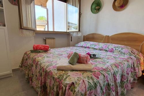 een slaapkamer met een bed met een bloemenbed bij La Butterfly in Torre del Lago Puccini