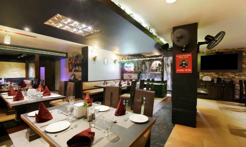 Un comedor con mesas y sillas en un restaurante. en Treebo Punjabi Nature Residency, Near Faridabad Railway Station, en Faridabad
