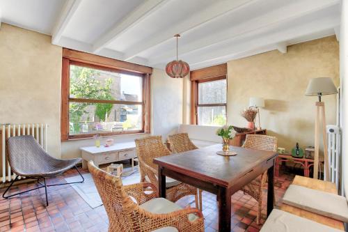 un salon avec une table et des chaises en bois dans l'établissement Presque Une Ile - Charmante maison vue mer, à Saint-Jacut-de-la-Mer