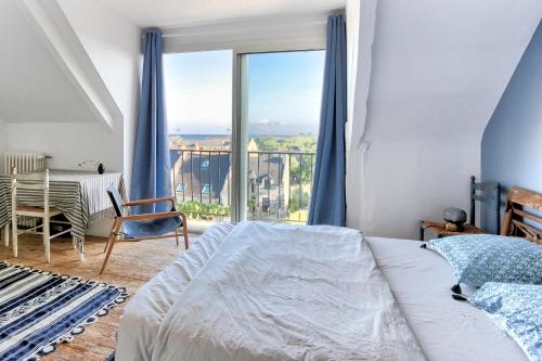 une chambre avec un lit et une grande fenêtre dans l'établissement Presque Une Ile - Charmante maison vue mer, à Saint-Jacut-de-la-Mer