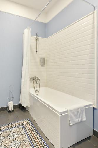 a white bath tub in a bathroom with blue walls at Stabu Sēta Residence in Rīga