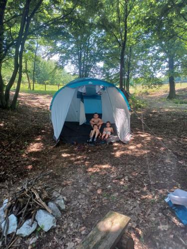 zwei Menschen sitzen in einem Zelt im Wald in der Unterkunft Plaiul Cucului in Tărcaia