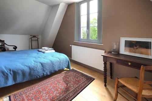una camera con letto, tavolo e finestra di La Mésangère a Marcilly-sur-Eure