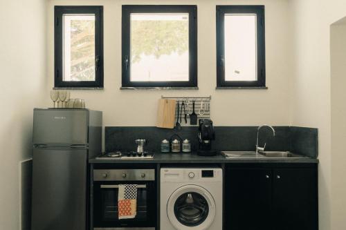 a kitchen with a refrigerator and a washing machine at FONDO MONDELLO in Mondello