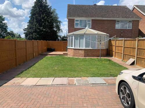 a house with a fence and a yard with a house with a gazilion at 3 Bedrooms spacious house in Calcot , Reading in Tilehurst