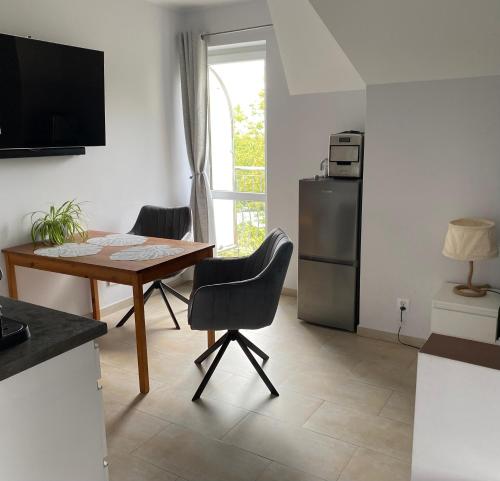 a kitchen with a table and chairs and a refrigerator at Apartament Bella in Międzyzdroje